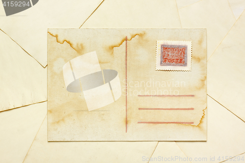 Image of Aged empty postcard with painted abstract postage stamp