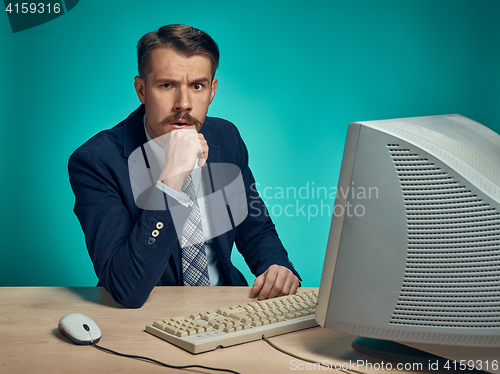 Image of Surprised Young Man Working On computer At Desk