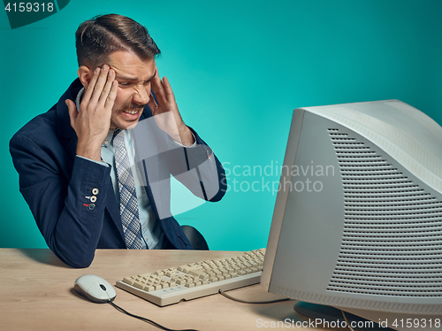 Image of Sad Young Man Working On computer At Desk