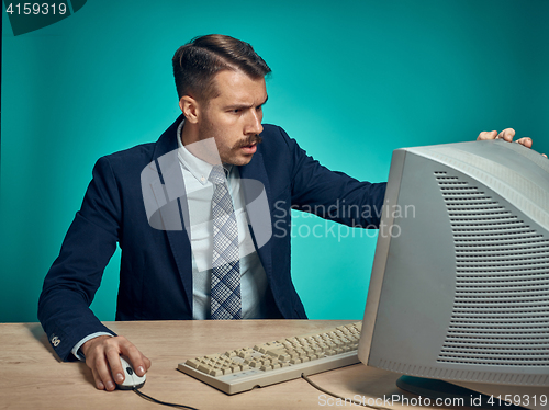 Image of Surprised Young Man Working On computer At Desk