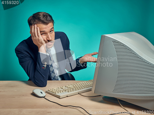 Image of Sad Young Man Working On computer At Desk