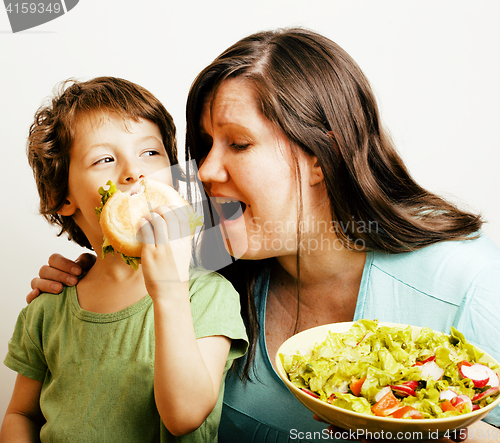 Image of fat woman holding salad and little cute boy with hamburger teasing