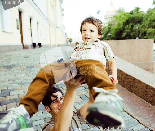 Image of little son with father in city hagging and smiling