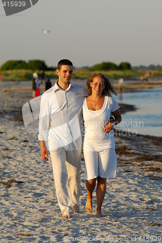 Image of Young couple walking on beach