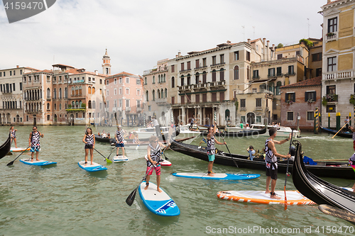 Image of Group of active tourists stand up paddling on sup boards at Grand Canal, Venice, Italy.