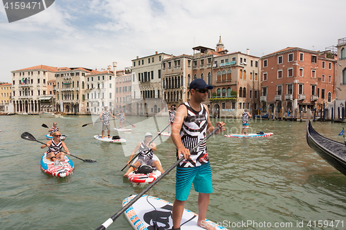 Image of Group of active tourists stand up paddling on sup boards at Grand Canal, Venice, Italy.