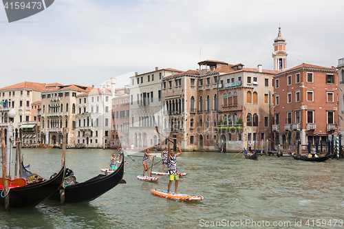 Image of Group of active tourists stand up paddling on sup boards at Grand Canal, Venice, Italy.