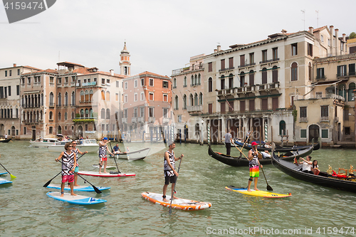 Image of Group of active tourists stand up paddling on sup boards at Grand Canal, Venice, Italy.