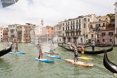 Image of Group of active tourists stand up paddling on sup boards at Grand Canal, Venice, Italy.