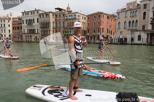 Image of Group of active tourists stand up paddling on sup boards at Grand Canal, Venice, Italy.