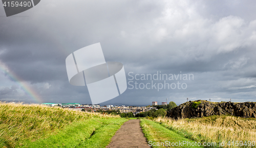 Image of cloudy sky and rainbow above the city