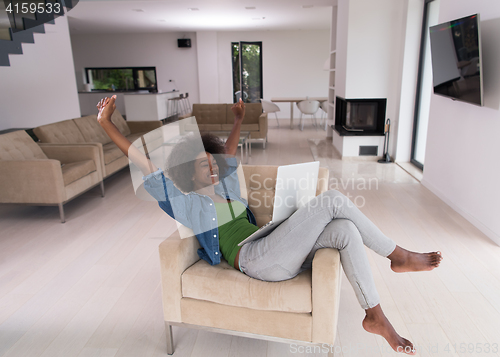 Image of African American women at home in the chair using a laptop