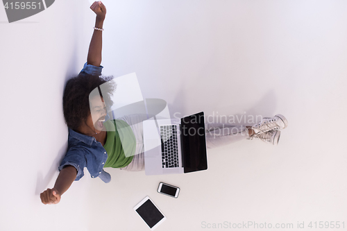 Image of african american woman sitting on floor with laptop top view