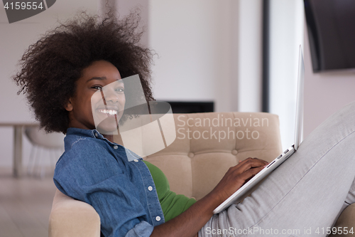 Image of African American women at home in the chair using a laptop