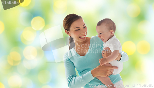 Image of happy mother with little baby over green lights