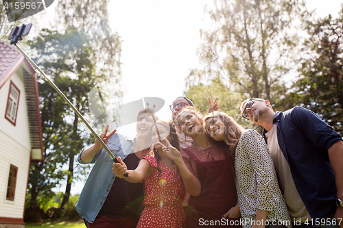 Image of friends taking selfie at party in summer garden