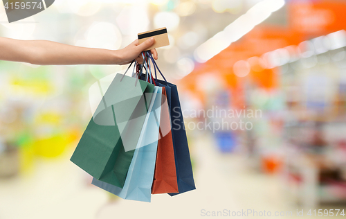 Image of hand with shopping bags and credit card at store