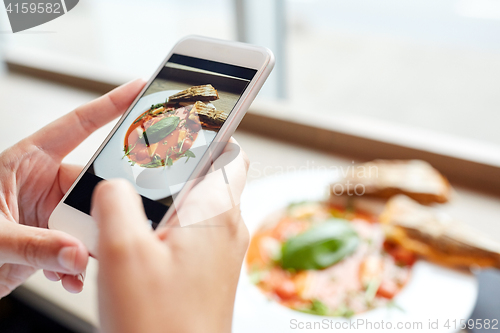 Image of hands with gazpacho soup photo on smartphone