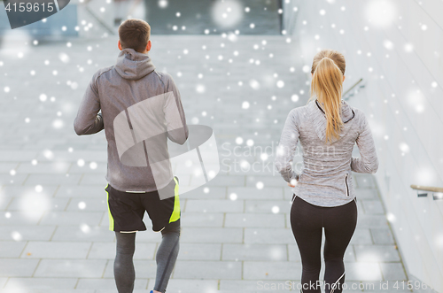 Image of couple of sportsmen running downstairs outdoors