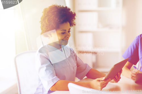 Image of happy female doctor or nurse with tablet pc