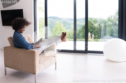 Image of african american woman at home with digital tablet