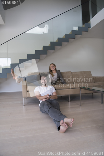 Image of Young couple on the sofa watching television