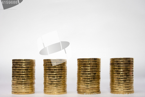 Image of Four identical height of the stack of coins on a light background, the top place for an inscription