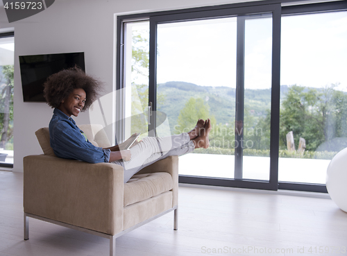 Image of african american woman at home with digital tablet