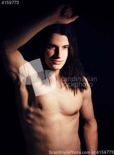 Image of handsome young man with long hair naked torso on black background