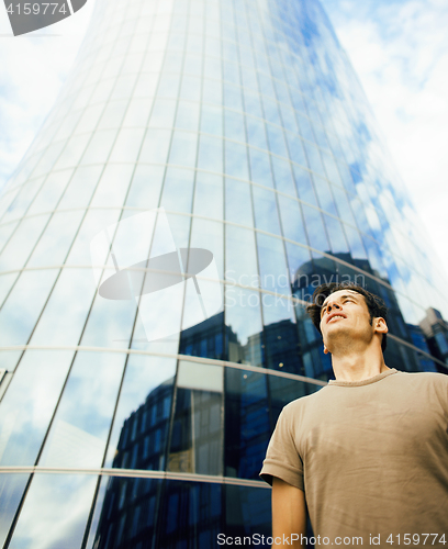 Image of young man stand in front of modern business building