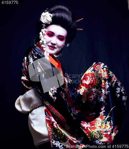 Image of young pretty geisha in kimono with sakura and decoration