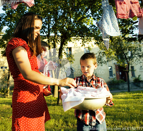 Image of woman with children in garden hanging laundry