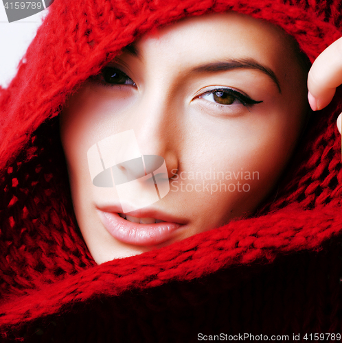 Image of young pretty woman in sweater and scarf all over her face