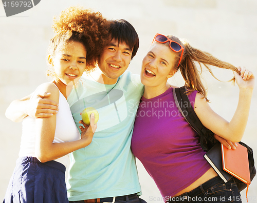 Image of cute group of teenages at the building of university with books huggings