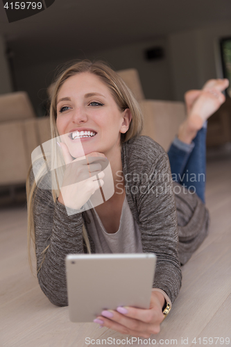 Image of young women used tablet computer on the floor