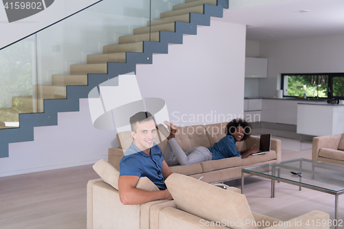 Image of young multiethnic couple relaxes in the living room