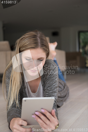 Image of young women used tablet computer on the floor