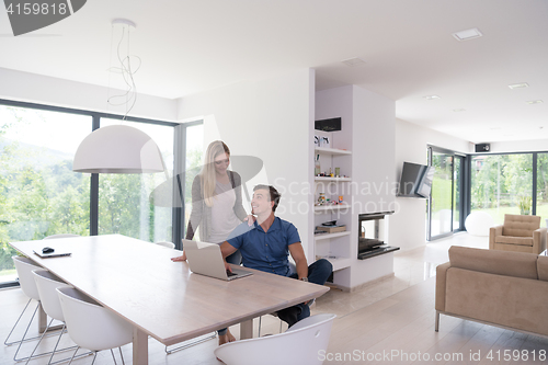 Image of couple using laptop at home