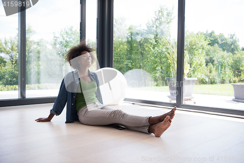 Image of african american  woman  sitting near window