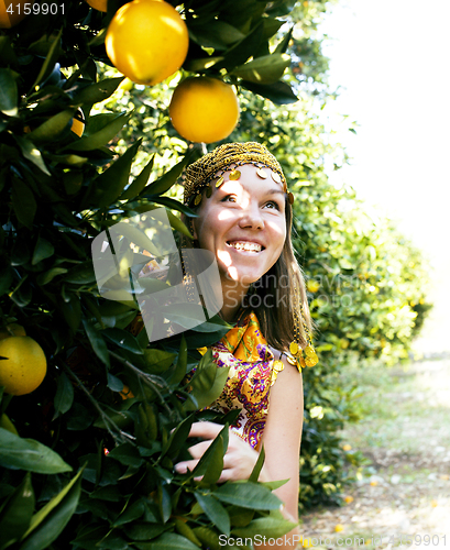 Image of pretty woman in orange grove smiling