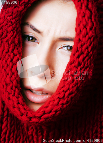 Image of young pretty woman in sweater and scarf all over her face