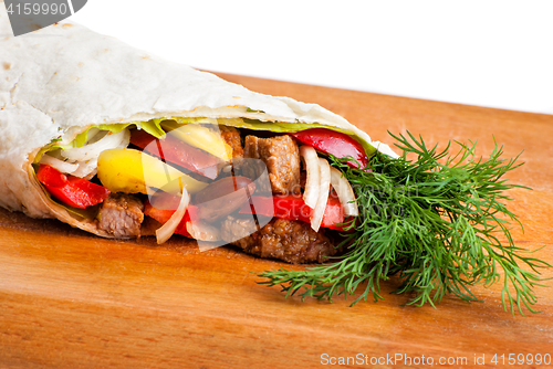 Image of beef burrito with peppers, onion and tomato