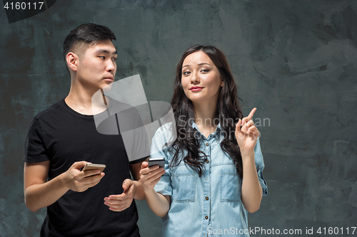 Image of Asian young couple using cellphone, closeup portrait.