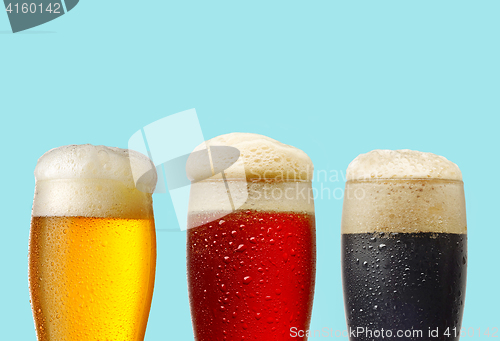 Image of various beer glasses on blue background