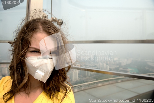 Image of Woman in medical mask against the air pollution