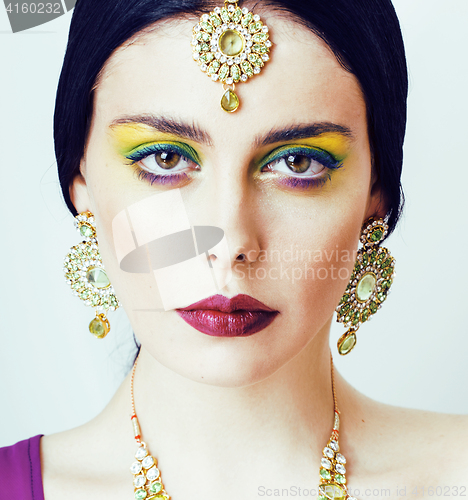 Image of young pretty caucasian woman like indian in ethnic jewelry close up on white, bridal makeup