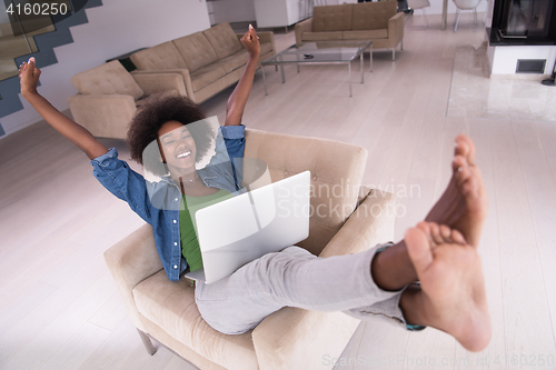 Image of African American women at home in the chair using a laptop