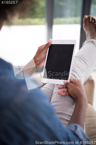 Image of african american woman at home with digital tablet