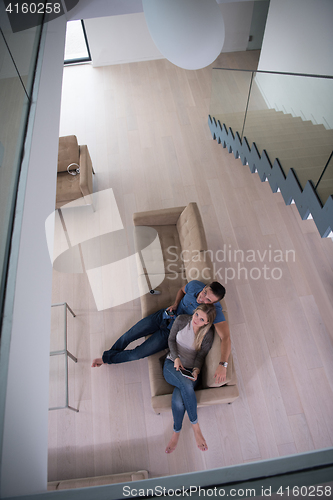 Image of youg couple in living room with tablet top view