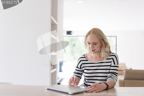 Image of Young woman with laptop at home